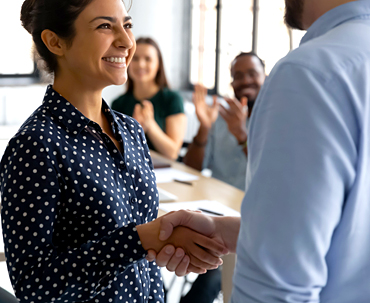 Happy female employee being congratulated as a new hire.